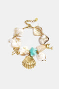 Bracelet orné de coquillages, de breloques marines et de perles dorées et bleues.