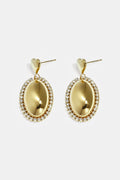 Boucles d'oreilles imposantes avec un pendentif ovale entouré de pierres