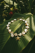 Collier Lumé coquillages breloques perles dorées — macro détail